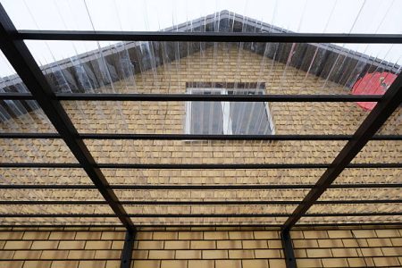 Canopy of a country house terrace made of metal structures and transparent roof made of profiled polycarbonate, construction process